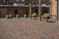 an industrially styled parking lot is dotted with brick bricks in a courtyard with many barrels on either side of the plaza