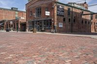 there is a brick road with a clock on it as well as a building in the background