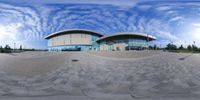 an 360 - lens photo of a circular design in front of a building and blue sky