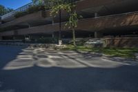 a building with a parking lot next to it's walkways and trees in the background