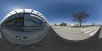 fisheye lens shot of a street at the edge of a building with two buildings behind