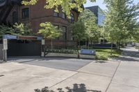 a sidewalk is near the building next to trees and a sidewalk lamp and stairs on the right side