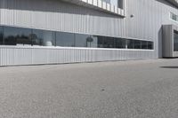 a building with people walking in front of it and cars parked next to the building