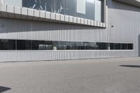 a building with people walking in front of it and cars parked next to the building