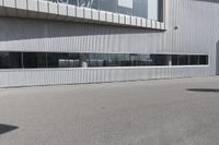 a building with people walking in front of it and cars parked next to the building