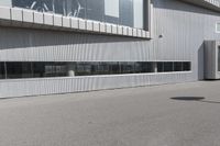 a building with people walking in front of it and cars parked next to the building