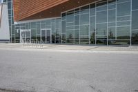 a fire hydrant in front of a large building with windows and doors near a parking lot