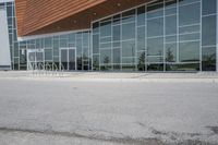 a fire hydrant in front of a large building with windows and doors near a parking lot