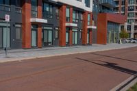 a sidewalk with a bicycle lane next to a building and street signs on the side of it