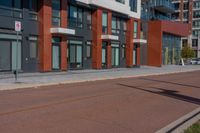 a sidewalk with a bicycle lane next to a building and street signs on the side of it