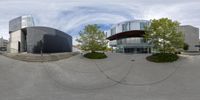 a fish eye lens panoramic view of a building that is next to trees and steps