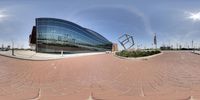 the circular photo shows an entrance to a building with a lot of windows and a sky