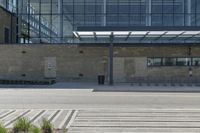 a concrete and glass building has a bench in front of it in the city street