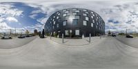 a 360 - degree panorama image of the outside of a building with cars around it