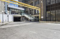 an empty building with stairs and metal railings next to the street and a parking ramp and entrance