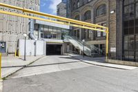 an empty building with stairs and metal railings next to the street and a parking ramp and entrance