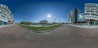 360 - view of some buildings, the sun is setting and the street is empty