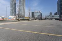 several buildings on an empty parking lot, in front of the other buildings and in front of a green fire hydrant