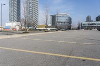 several buildings on an empty parking lot, in front of the other buildings and in front of a green fire hydrant