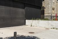 the red fire hydrant stands next to a large black metal door in front of a building