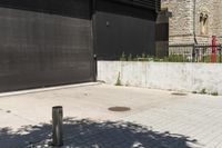 the red fire hydrant stands next to a large black metal door in front of a building