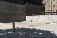 the red fire hydrant stands next to a large black metal door in front of a building