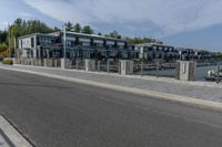 a large gray apartment complex sitting beside the water near a waterway with boats in it