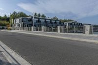 a large gray apartment complex sitting beside the water near a waterway with boats in it