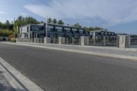 a large gray apartment complex sitting beside the water near a waterway with boats in it