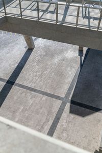 the shadow of an umbrella and luggage can be seen from above in a large atrium area