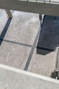 the shadow of an umbrella and luggage can be seen from above in a large atrium area