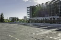 there is a parking lot in the middle of a large, open building with windows and many pine trees