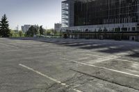 there is a parking lot in the middle of a large, open building with windows and many pine trees