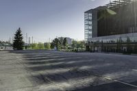 there is a parking lot in the middle of a large, open building with windows and many pine trees