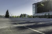 there is a parking lot in the middle of a large, open building with windows and many pine trees