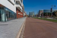 a large paved city street next to a large building on the other side of it