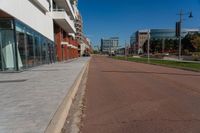 a large paved city street next to a large building on the other side of it