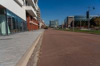 a large paved city street next to a large building on the other side of it