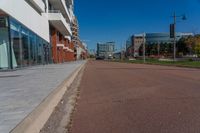 a large paved city street next to a large building on the other side of it