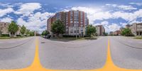 some buildings are behind the trees and on a cloudy day in this 360 - view picture