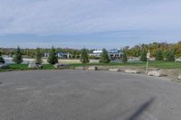 a parking lot with a stop sign and several other parked vehicles parked by the road