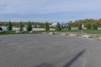 a parking lot with a stop sign and several other parked vehicles parked by the road