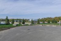 a parking lot with a stop sign and several other parked vehicles parked by the road