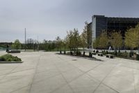 a concrete path and walkway in front of a building with many trees and bushes on the sides