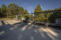 the concrete walkway that runs around an elevated metal structure in the woods is made out of silver steel bars