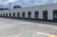 yellow arrows in an empty parking lot by an industrial building with large windows and signs