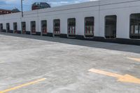 yellow arrows in an empty parking lot by an industrial building with large windows and signs