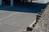 cars parked on the side of the road at a large garage area next to a highway