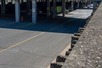 cars parked on the side of the road at a large garage area next to a highway