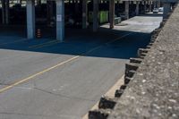 cars parked on the side of the road at a large garage area next to a highway